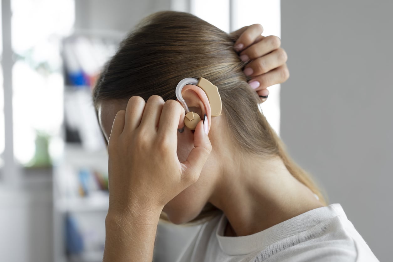 Woman adjusting her hearing aid
