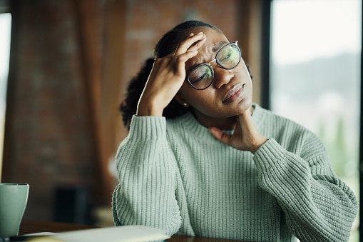 Stressed woman sitting at a table looking worried