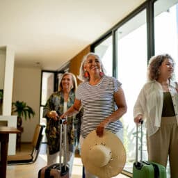 Travelling group of friends arrives at their vacation rental with their luggage.