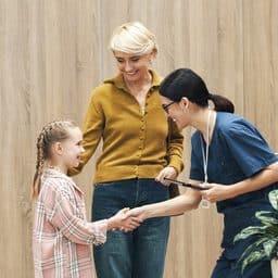 Mother and daughter meeting a practitioner before the daughter's hearing appointment